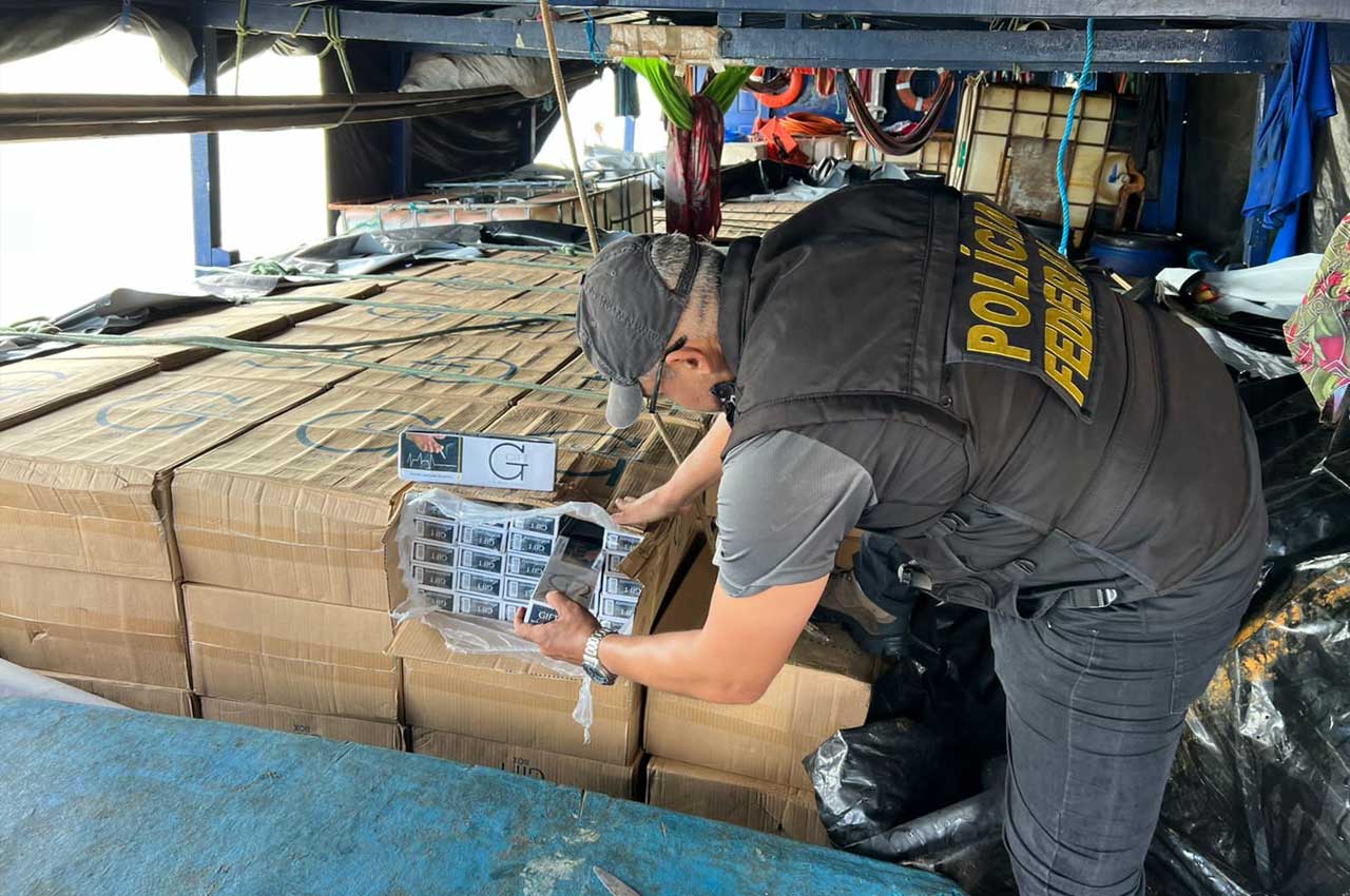 Policial Federal averiguando carga de cigarros apreendidos na costa do nordeste